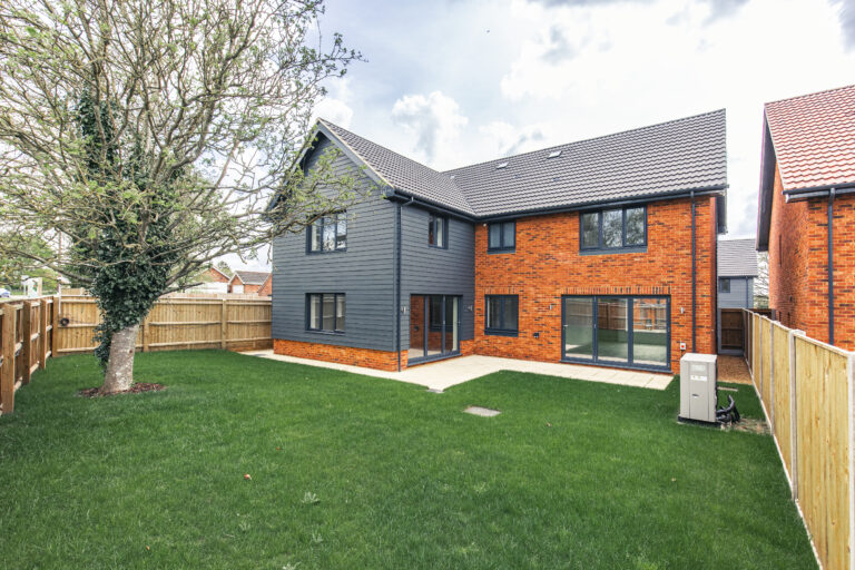 Rear external view of Plot 4, 4 bedroom detached home with large turfed garden and two sets of bi-folding doors.