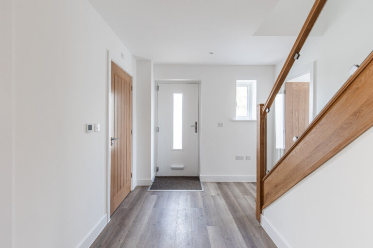 Hallway of 4 bedroom property with solid oak and glass staircase.