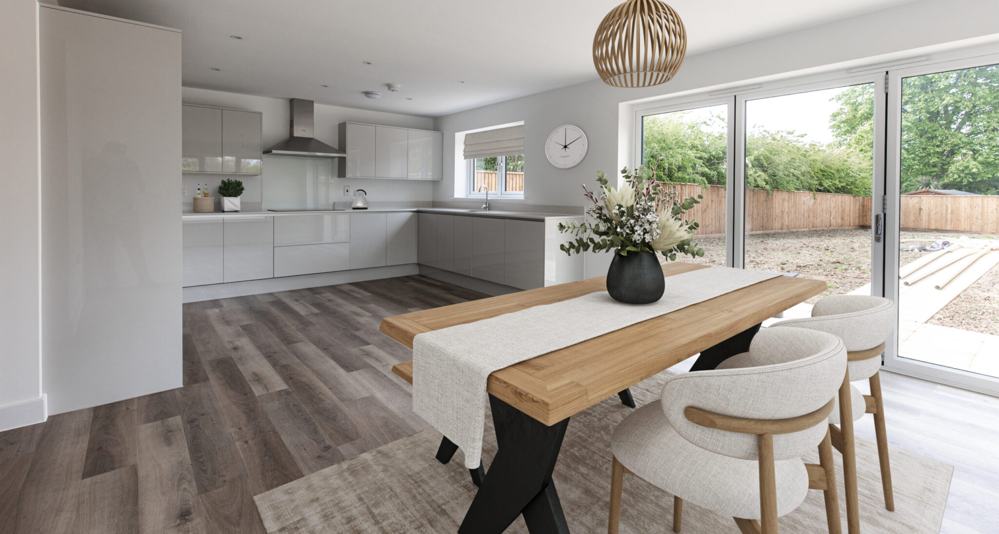 Open plan kitchen dining room with four seater dining table and bifolding doors leading out to garden.