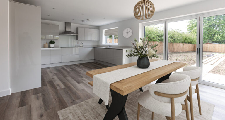Open plan kitchen dining room with four seater dining table and bifolding doors leading out to garden.