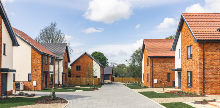 External view looking down development with brick weaved road.